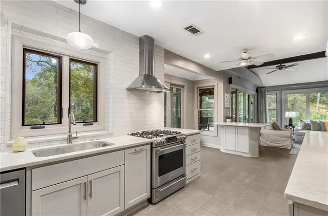 a kitchen with stainless steel appliances granite countertop a stove a sink and a refrigerator