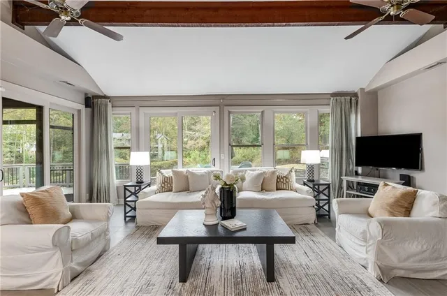 a living room with furniture and a dining table with kitchen view