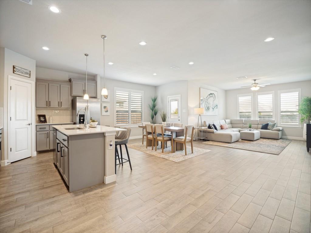 1612 Reed Drive Krum, TX 76249 - Photo 8 of 25 Open-concept living area featuring wood-finish flooring, recessed lighting, and a modern kitchen island with pendant lighting