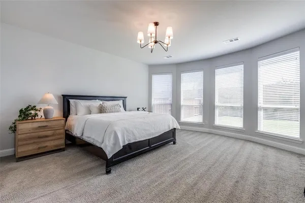 a spacious bedroom with a bed and a large window