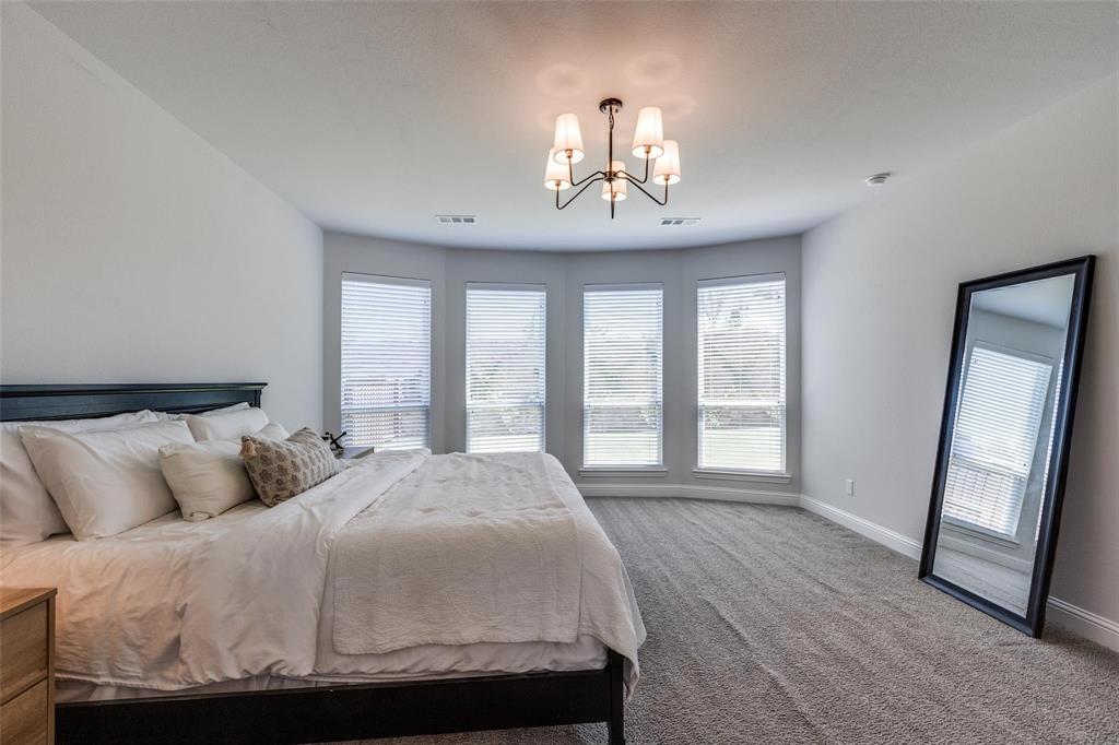 1000 Adair Road Prosper, TX 75078 - Photo 16 of 38 HUGE primary bedroom overlooks the ultra private rear yard. More than enough room for a sitting area in the extended portion of the primary bedroom.