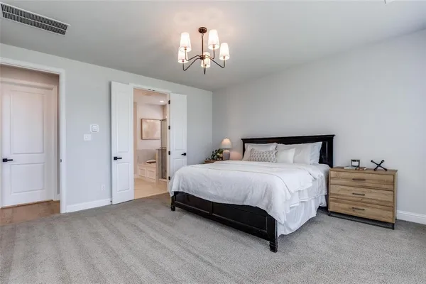 a bedroom with a bed and a chandelier