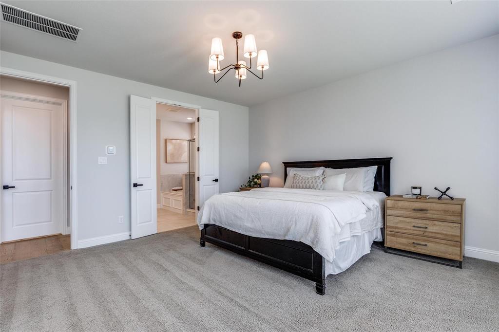 1000 Adair Road Prosper, TX 75078 - Photo 17 of 38 Primary bedroom featuring baseboards, a chandelier, and ensuite bathroom even with a large bed and large nightstands this MASSIVE bedroom has plenty of room for a sitting area....