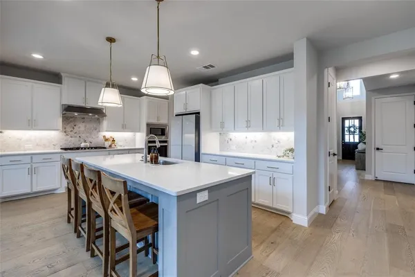 a kitchen with granite countertop a table chairs sink and cabinets