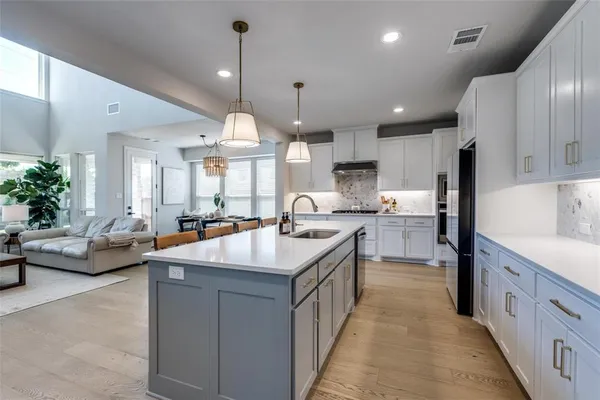 a kitchen with counter top space a sink cabinets and stainless steel appliances