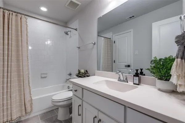 a bathroom with a sink a toilet a tub and shower