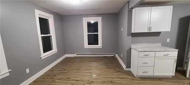 an entryway with wooden floor and cabinet