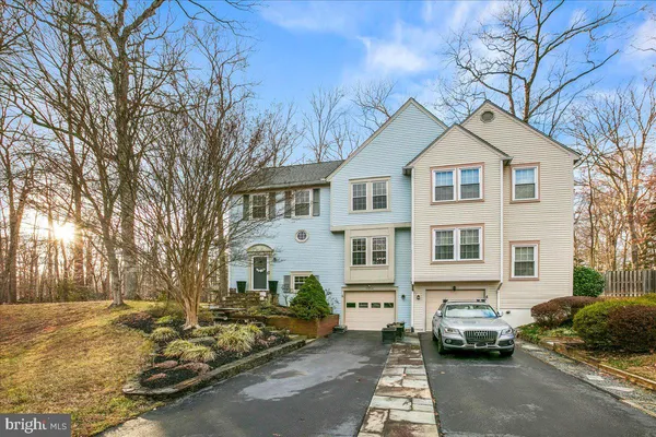 a front view of a house with cars parked