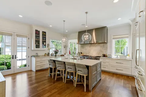 a kitchen with stainless steel appliances and wooden floor