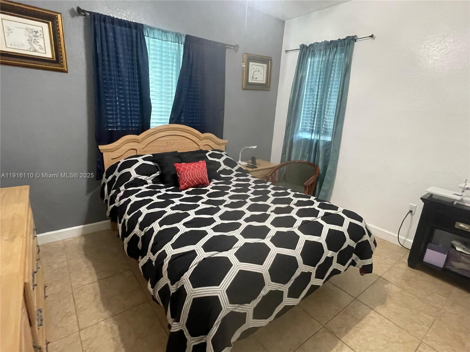 3102 Northeast 3rd Drive Homestead, FL 33033 - Photo 17 of 33 a bedroom with a bed and a mirror