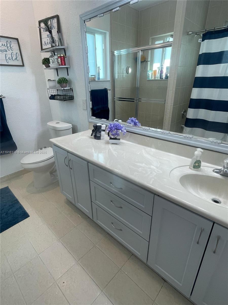 3102 Northeast 3rd Drive Homestead, FL 33033 - Photo 21 of 33 a bathroom with a sink and mirror with toilet