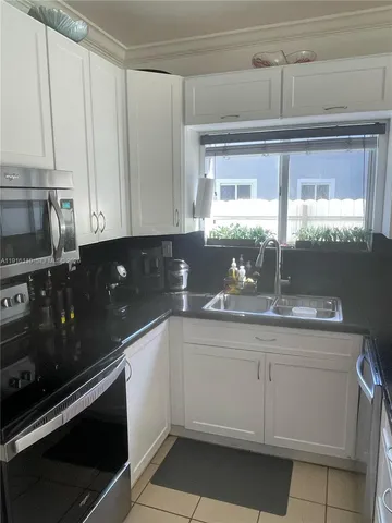 a kitchen with a sink cabinets and window