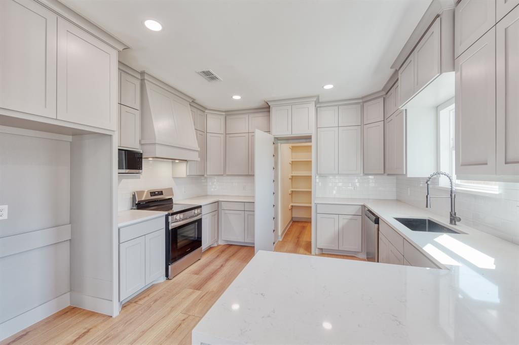 808 North Main Street Tioga, TX 76271 - Photo 12 of 23 a kitchen with granite countertop a sink a counter top space stainless steel appliances and cabinets