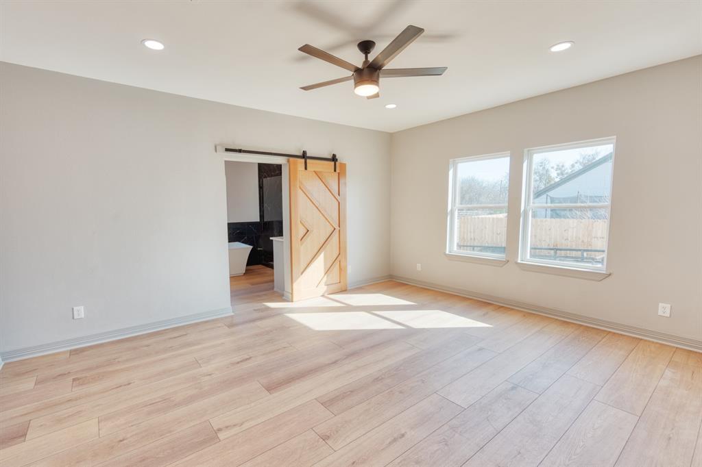 808 North Main Street Tioga, TX 76271 - Photo 13 of 23 an empty room with wooden floor and windows