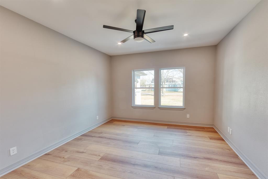 808 North Main Street Tioga, TX 76271 - Photo 17 of 23 wooden floor in an empty room with a window
