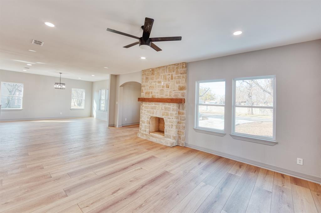 808 North Main Street Tioga, TX 76271 - Photo 7 of 23 a view of a livingroom with a fireplace a ceiling fan and windows