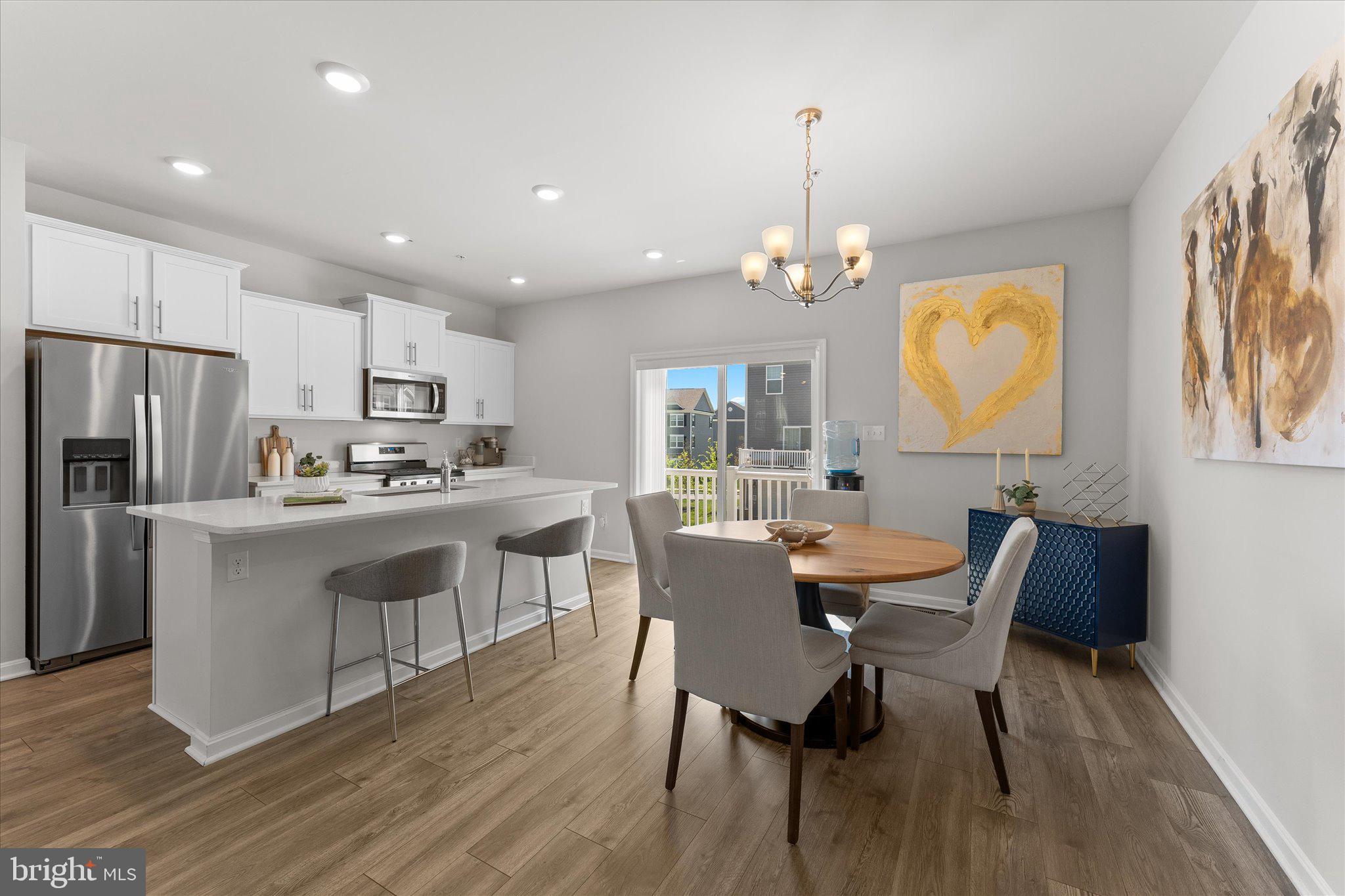 9611 Silver Bluff Way Bowie, MD 20721 - Photo 12 of 33 a kitchen with stainless steel appliances granite countertop a dining table chairs refrigerator and microwave