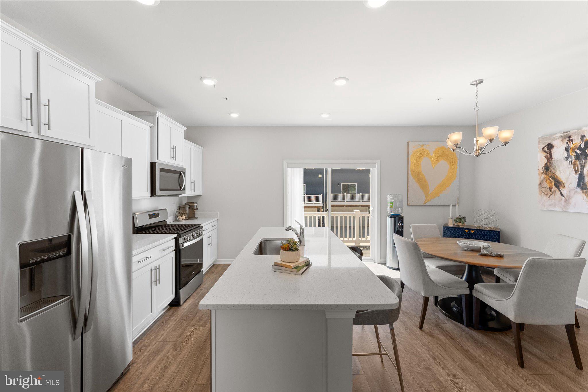 9611 Silver Bluff Way Bowie, MD 20721 - Photo 8 of 33 a kitchen with stainless steel appliances granite countertop a stove refrigerator a sink dishwasher a dining table and chairs with wooden floor