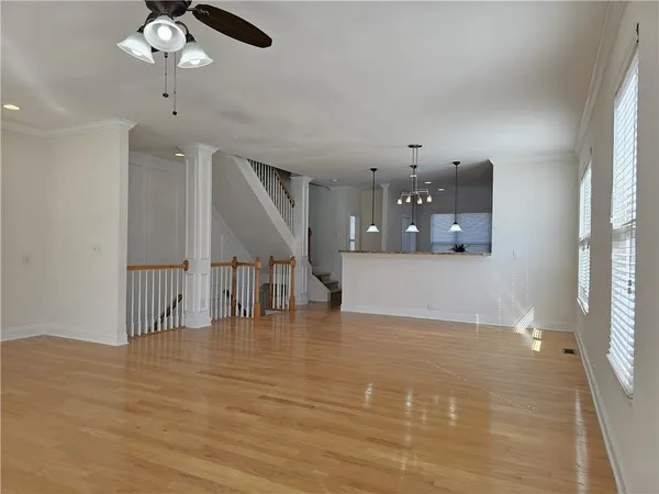 a view of a room with wooden floor staircase and a kitchen