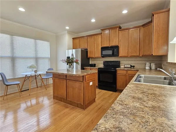 a kitchen with stainless steel appliances granite countertop wooden cabinets a stove top oven a sink and dishwasher