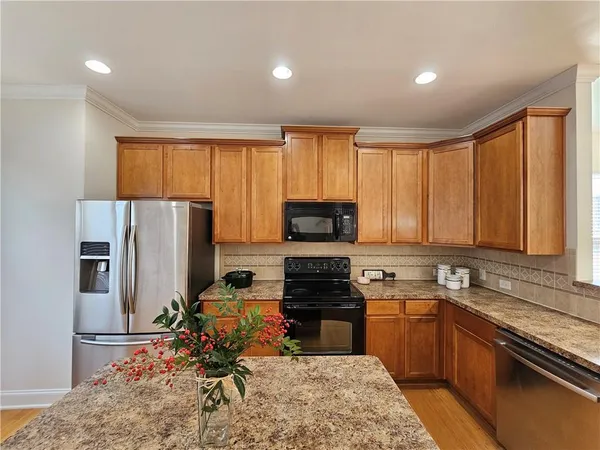 a kitchen with a refrigerator a stove top oven a sink and cabinets