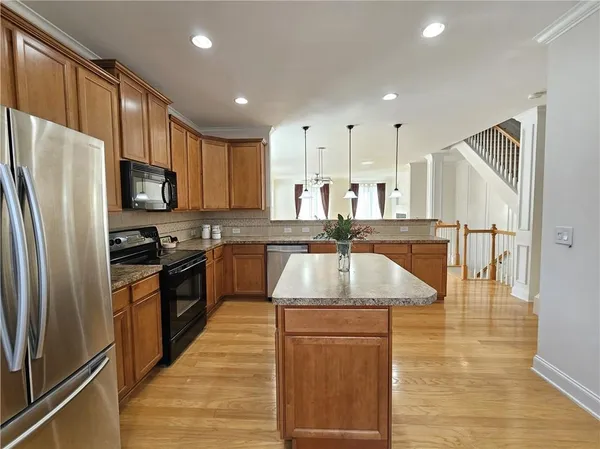 a kitchen with stainless steel appliances granite countertop a sink refrigerator and cabinets