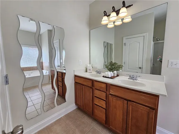 a bathroom with a double vanity sink a mirror and a shower
