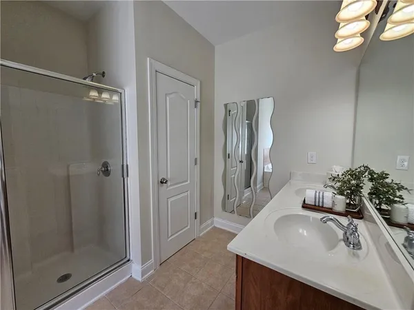 a bathroom with a sink and a mirror with shower