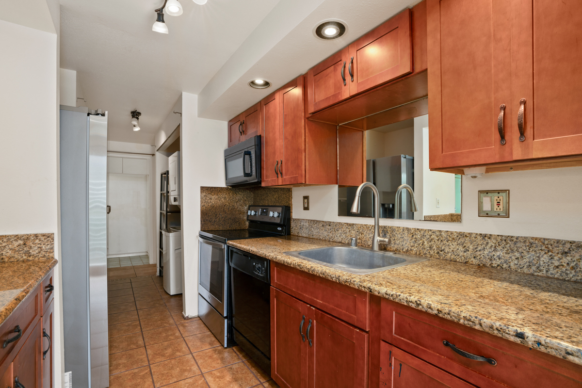 3057 Poipu Road, Unit A1 Koloa, HI 96756 - Photo 2 of 19 a kitchen with stainless steel appliances granite countertop a sink stove and refrigerator