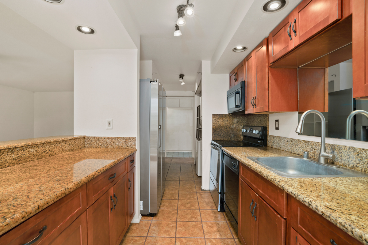 3057 Poipu Road, Unit A1 Koloa, HI 96756 - Photo 3 of 19 a kitchen with a sink stove and refrigerator