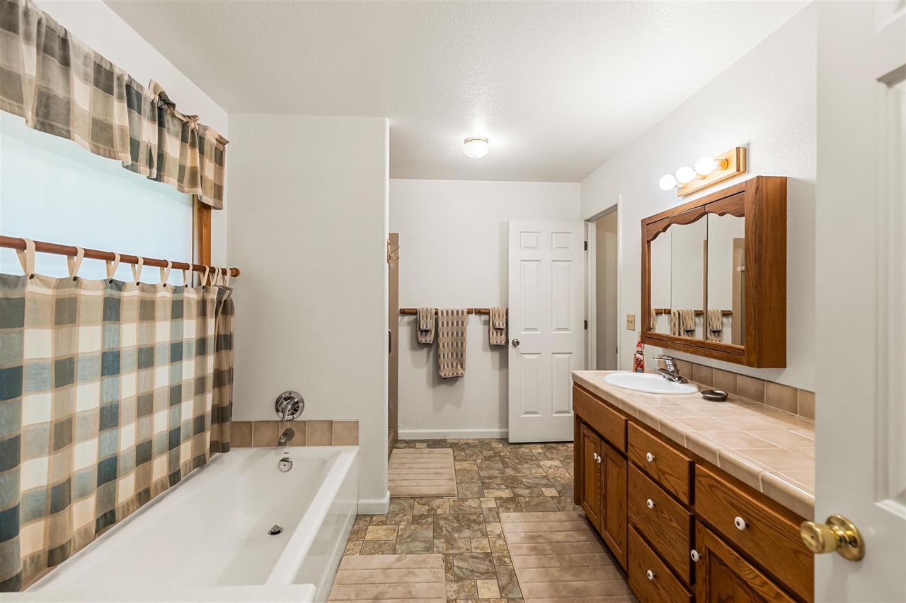 16554 Cocoran Gray Road Groveland, CA 95321 - Photo 14 of 38 Bathroom featuring tile floors, a bathing tub, and vanity