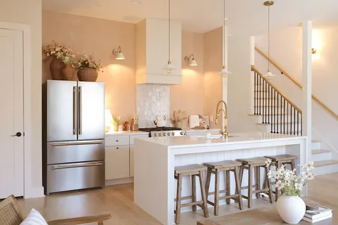 a kitchen with kitchen island a stove a refrigerator and a sink with wooden floor