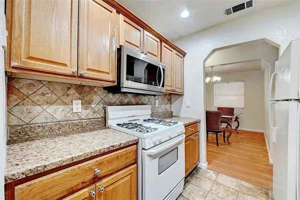 a kitchen with stainless steel appliances granite countertop a stove and a microwave
