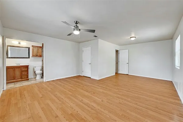 a view of empty room with fireplace and wooden floor