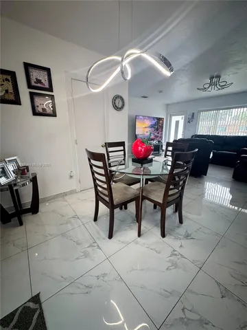 a view of a dining room with furniture and chandelier