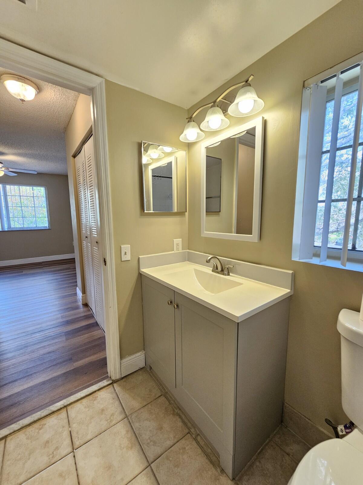4191 Haverhill Road, Unit 408 West Palm Beach, FL 33417 - Photo 19 of 22 a bathroom with a sink and mirror with bathtub