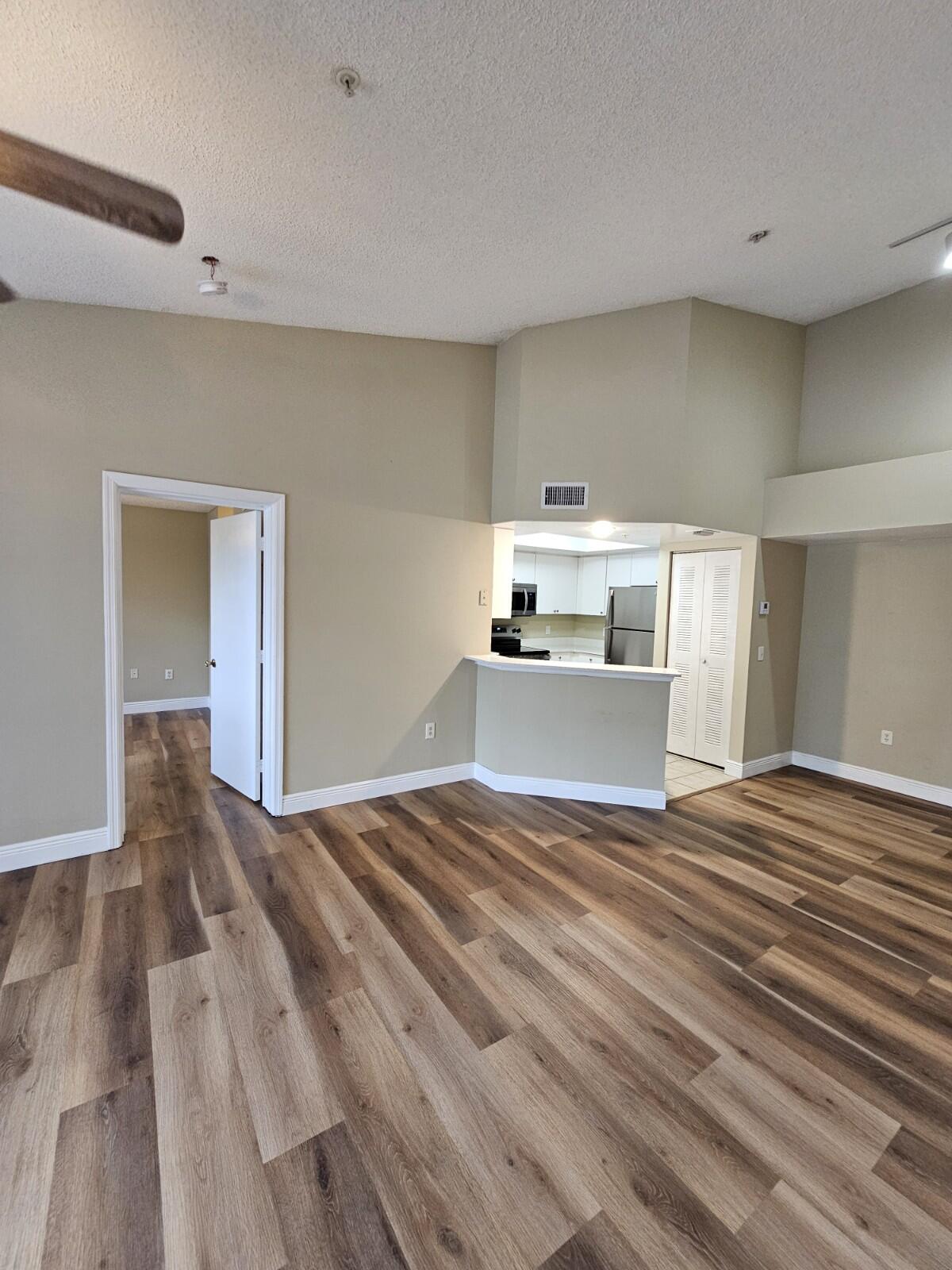4191 Haverhill Road, Unit 408 West Palm Beach, FL 33417 - Photo 2 of 22 a view of a livingroom with wooden floor and kitchen space