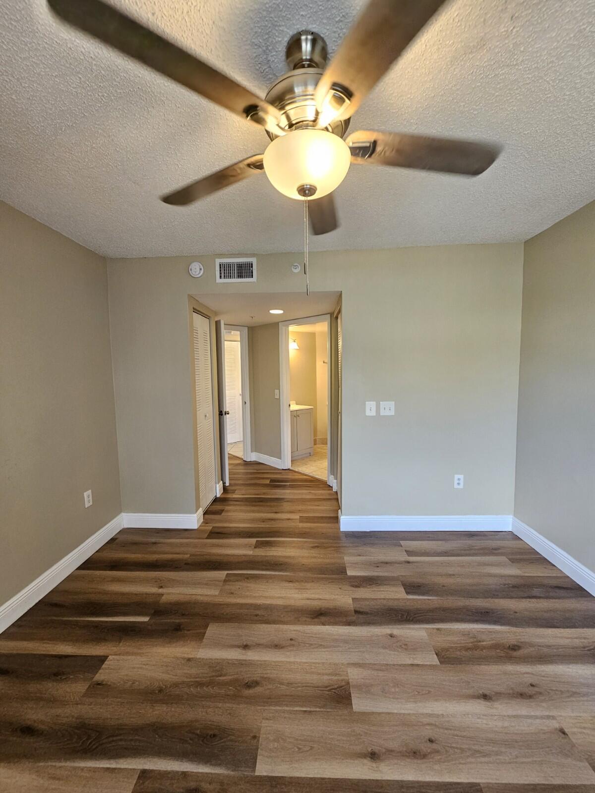 4191 Haverhill Road, Unit 408 West Palm Beach, FL 33417 - Photo 8 of 22 a view of a chandelier fan and wooden floor