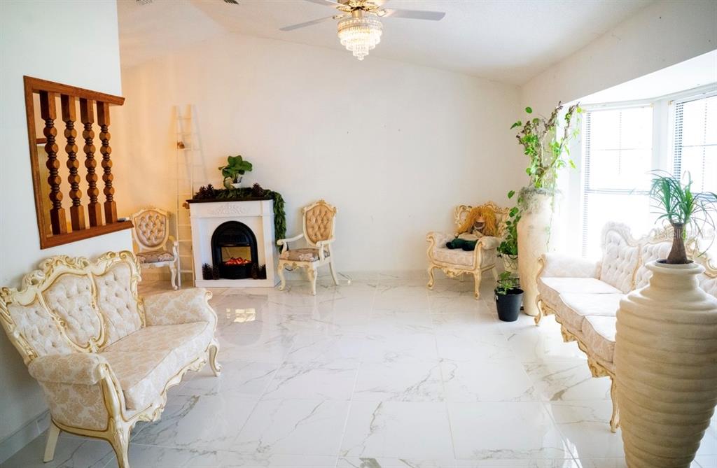 4150 South Apopka Avenue Inverness, FL 34452 - Photo 21 of 84 a living room with furniture a fireplace and a potted plant