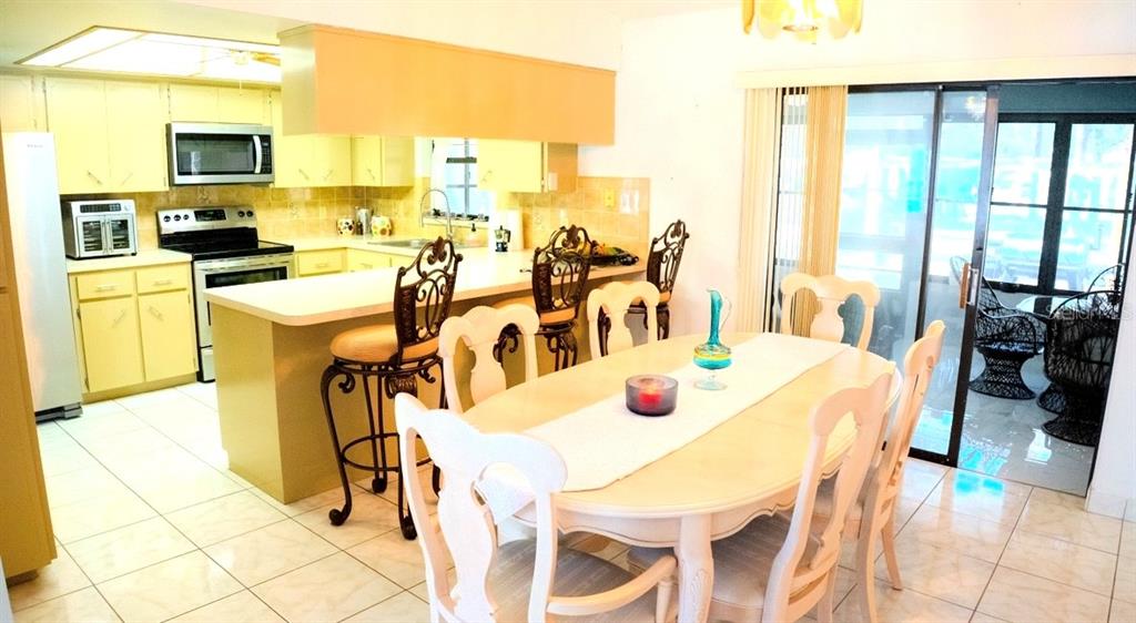 4150 South Apopka Avenue Inverness, FL 34452 - Photo 23 of 84 a dining room with stainless steel appliances furniture a large window and a kitchen view