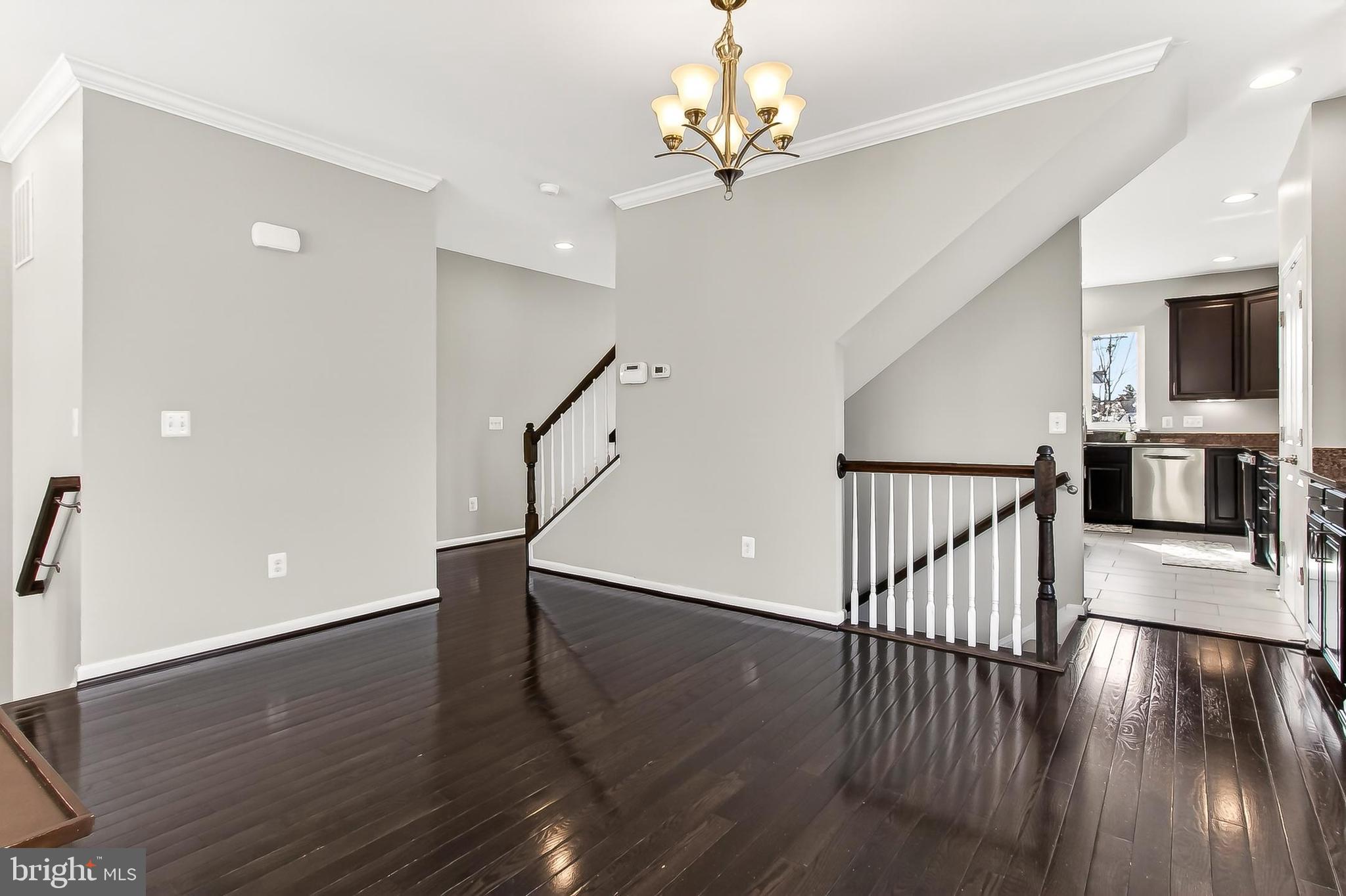43473 Hopestone Terrace Chantilly, VA 20152 - Photo 14 of 49 a view of a room with wooden floor staircase and kitchen view