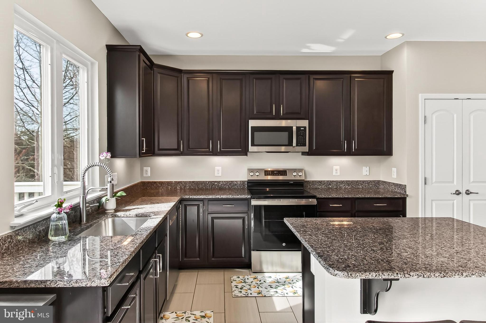 43473 Hopestone Terrace Chantilly, VA 20152 - Photo 19 of 49 a kitchen with granite countertop a sink a stove and cabinets