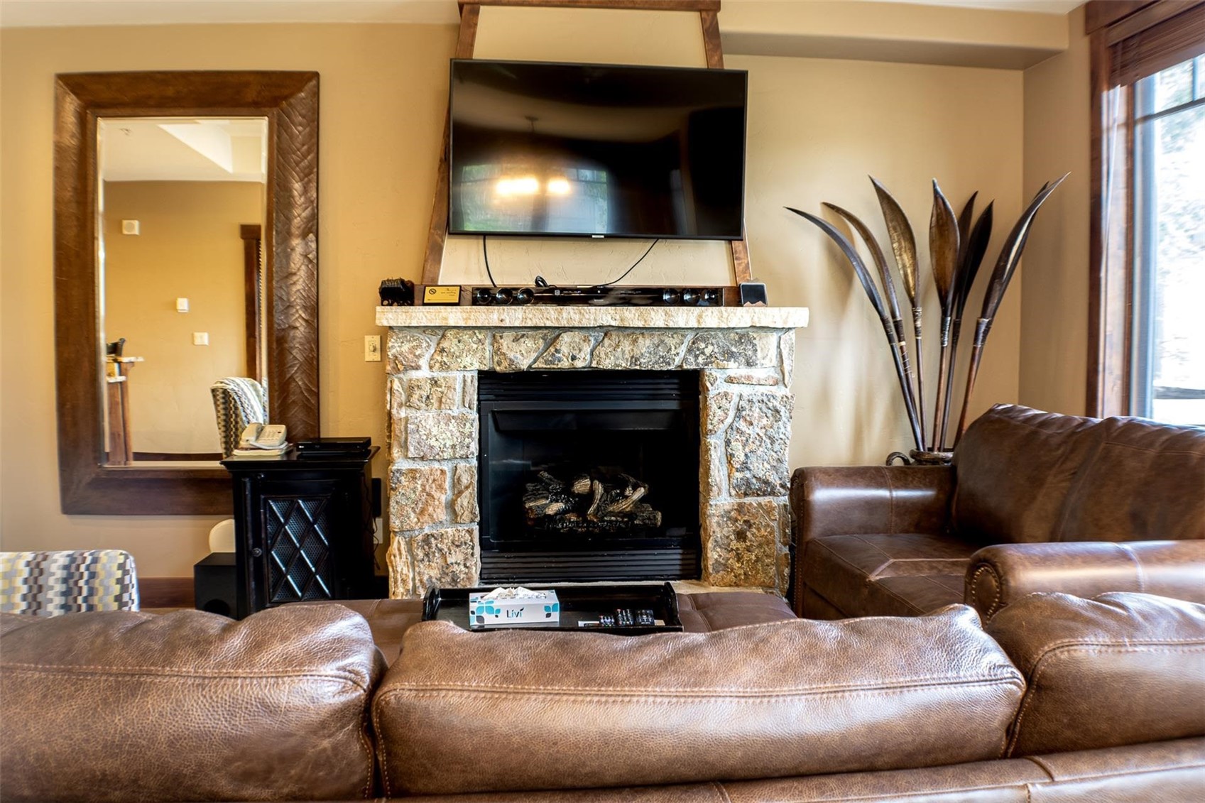1891 Ski Hill Road, Unit 7000 Breckenridge, CO 80424 - Photo 11 of 25 a living room with furniture a fireplace and a flat screen tv