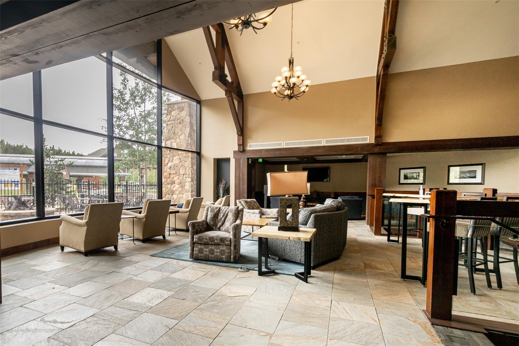 1891 Ski Hill Road, Unit 7000 Breckenridge, CO 80424 - Photo 21 of 25 a living room with furniture a flat screen tv and a floor to ceiling window