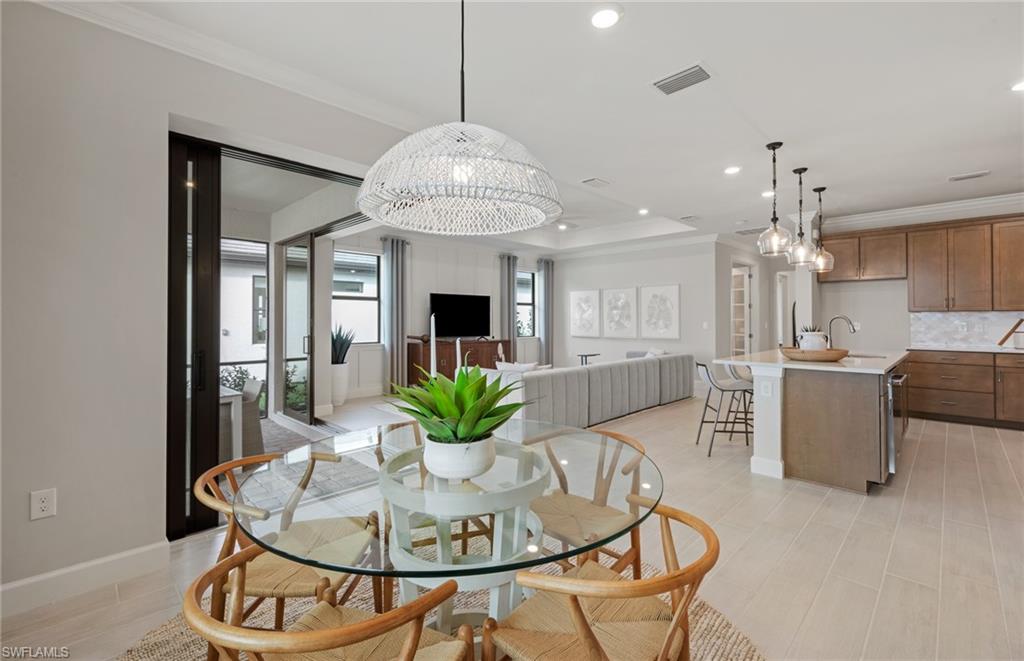 20498 Pebble Gln Drive Estero, FL 33928 - Photo 23 of 46 a dining room with furniture a chandelier and wooden floor