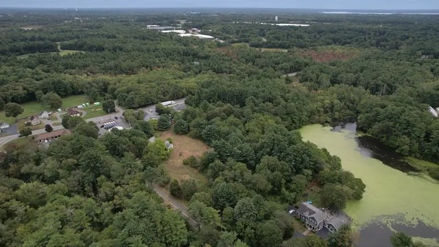 an aerial view of residential house with outdoor space and trees all around