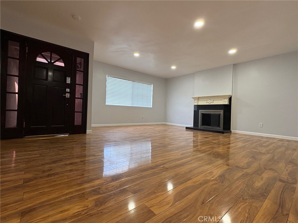 20730 Community Street Winnetka, CA 91306 - Photo 2 of 12 a view of empty room with wooden floor and fireplace