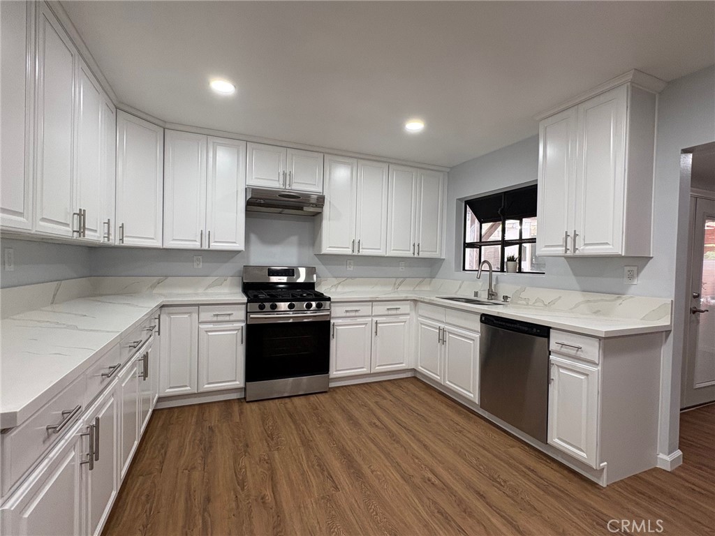 20730 Community Street Winnetka, CA 91306 - Photo 4 of 12 a kitchen with granite countertop a stove top oven sink and cabinets