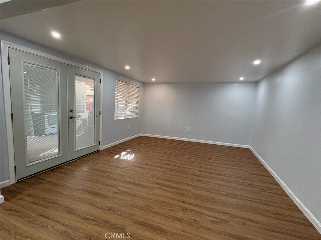 20730 Community Street Winnetka, CA 91306 - Photo 6 of 12 an empty room with wooden floor and windows
