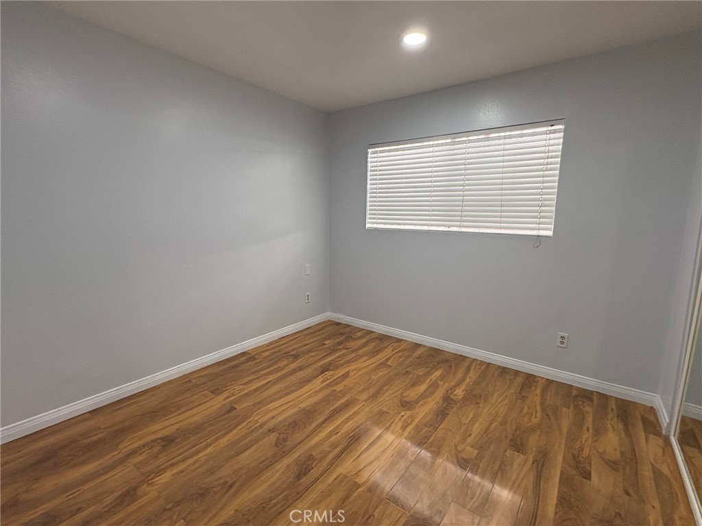 20730 Community Street Winnetka, CA 91306 - Photo 8 of 12 a view of an empty room with wooden floor and a window